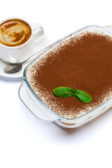 Traditional Italian Tiramisu dessert in glass baking dish and cup of fresh espresso coffee isolated on white background with clipping path