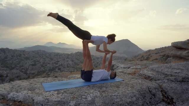Couple practicing acro yoga in nature