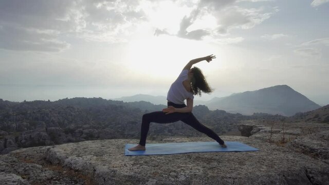 Unrecognizable woman practicing balancing yoga asana in nature