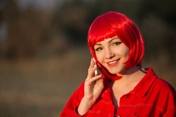 portrait of beautiful young female with red hair with mobile phone