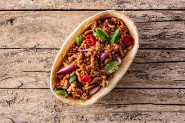 Mexican barquita taco with beef, chilli, tomato, onion and spices on wooden table. Top view.Copy space	