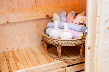 Fototapeta na wymiar Thai traditional medicine equipment in the sauna and spa room.Herbal ball and towel on bamboo basket.