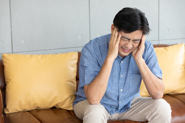 senior asian man suffering from headache at home