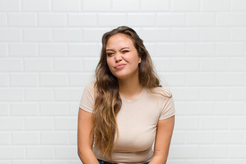 looking happy and friendly, smiling and winking an eye at you with a positive attitude