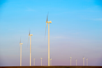 Fototapeta premium Windmills for electric power production at sunset