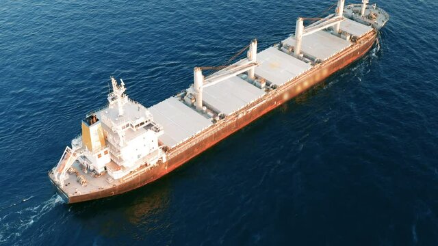 Cargo ship sailing on the ocean to the sea port. A bulk carrier or bulker - a merchant ship specially designed to transport unpackaged bulk cargo, such as grains, ore, coal or timber