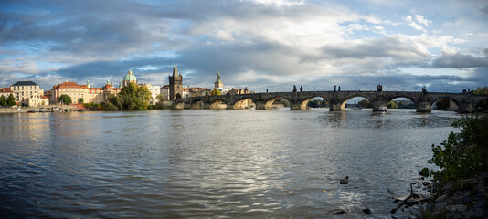 Obraz premium moving cinematic shot of Charles Bridge and flowing Vltava river at sunset in the center of Prague in the Czech Republic