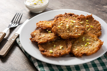 Traditional Jewish latkes or potato pancakes on wooden table
