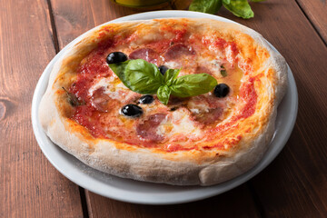 Pizza con salame, olive nere, mozzarella e pomodoro 