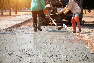 Workers pouring concrete with a cement mixer truck