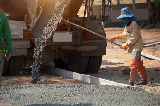 Workers pouring concrete with a cement mixer truck