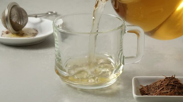 Pouring fresh made Lapacha tea in a glass cup