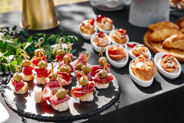 Outdoor catering banquet in summer. Table with snacks and canapes  at a summer banquet