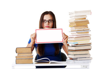 Beautiful young woman stuydent wih stack of books and holding co