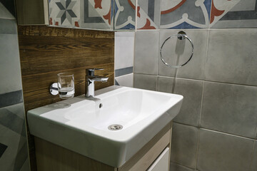Modern sinks with a mirror in a public toilet. Bachelor's reflection in the mirrors.