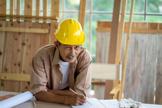senior Asian man working on wood  work home improvement DIY in workshop recoding streaming online