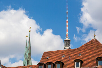 steeple and top of the berlin tv tower behind a red roof © Yay Images