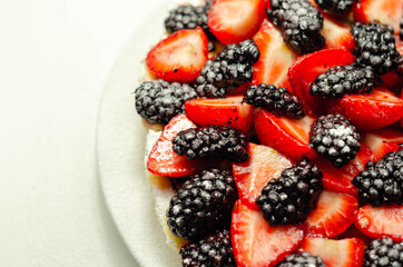 Butter enriched shortcrust pastry topped strawberries and blackberries, seasonal cake with colorful decoration
