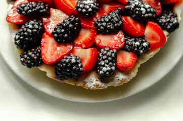 Butter enriched shortcrust pastry topped strawberries and blackberries, seasonal cake with colorful decoration