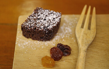Slice of a rich and chewy mini chocolate brownie with some raisins