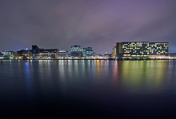 Fototapeta na wymiar Modern architecture along the Kalvebod Brygge waterfront illuminated at night