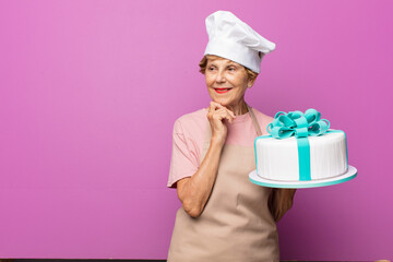 mature beautiful old woman smiling with a happy, confident expression with hand on chin, wondering and looking to the side