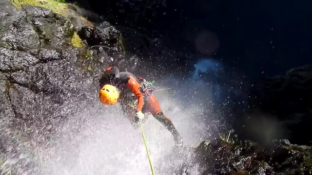 A man rappelling down a ravine in Reunion Island.