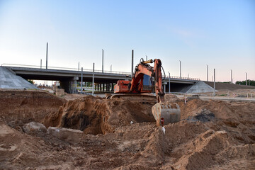Excavator during excavation at construction site. Backhoe on road work. Heavy Construction...