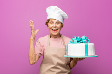 mature beautiful old woman feeling happy, excited, surprised or shocked, smiling and astonished at something unbelievable