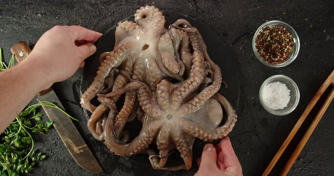 A stone board with raw octopus is put on the table.