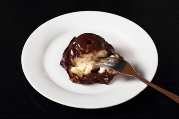 Profiterole with chocolate ganache frosting.  Choux pastry ball with custard filling and chocolate sauce icing.