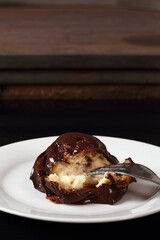 Profiterole with chocolate ganache frosting.  Choux pastry ball with custard filling and chocolate sauce icing.