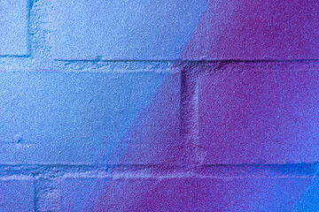 Beautiful bright colorful street art graffiti background. Abstract creative spray drawing fashion colors on the brick walls of the city. Urban Culture blue , purple, neon gradient backdrop
