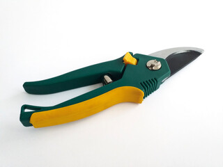Green and yellow steel garden pruning shears isolated on white background. Garden tool to prune and cut the stems and branches of unwanted plants. Garden shears with wooden handle isolated on white.