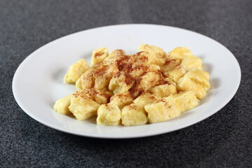 Gnocchi. Small soft dough dumplings with cottage cheese, honey and cinnamon on plate.