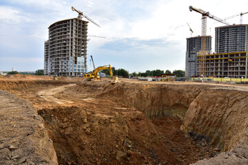 Digging the pit foundation a hole with excavator. Earthwork in excavation and backfilling of soil...