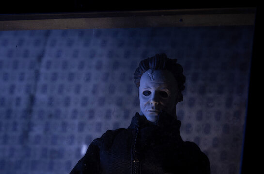 NEW YORK USA - AUG 31 2019: recreation of a scene from a Halloween movie with killer Michael Myers stalking from behind a window at night - Custom action figure using Funko Savage head and Mego body