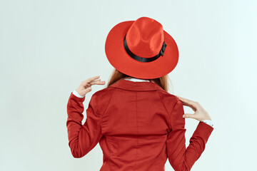 Woman in red hat and jacket back view elegant style light background
