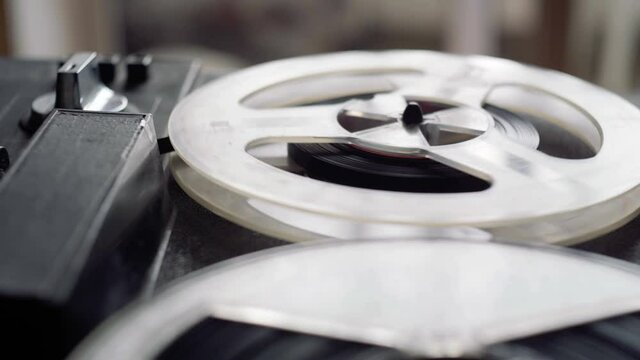 Reel film tape is rotating at a vintage professional player. Oldschool equipment