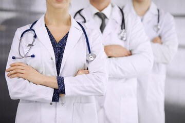 Doctors standing as a team with arms crossed in clinic. Medical help, insurance and medicine concept