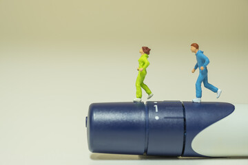 Sport, diabetes, health care and people concept - close up of  two runner miniature figures running on lancet for check blood sugar level.