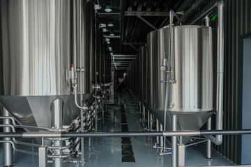 Lines of metal tanks in a modern craft brewery. Fermentation. 