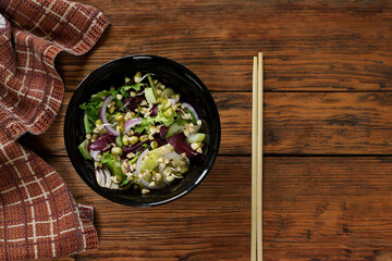 top view of a salad plate of fresh green cucumbers, celery, lettuce, red purple onions, raw buckwheat sprouts, sprouted mung bean vegan food concept Salad with vegetables and greens