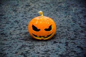 
In the center of the photo is a Halloween pumpkin with a blurred background.