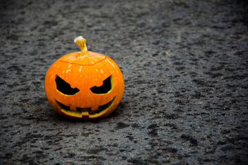 
Halloween pumpkin in the left corner against a dark background with a blurred background