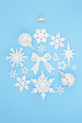Abstract Christmas round bauble decoration with white & frosted xmas decorations on pastel blue background. Festive composition for the winter, Xmas & New Year holiday season. Top view, flat lay.