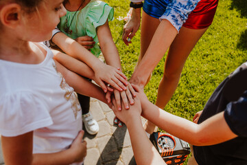 Young friends hands grouped together while birthday game. View from above.