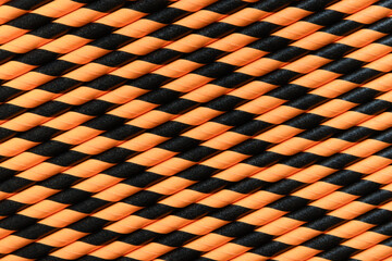 Halloween orange and black striped drinking straws as background. Top view. Pattern.