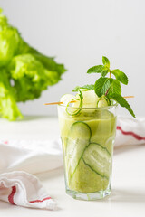 Broccoli and cucumber smoothie, delicious healthy drink made from green vegetables, a glass of smoothies on a white background, garnish of cucumbers and mint