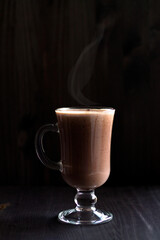 cup of hot chocolate. glass of cappuccino on a dark table. drinks on a wooden background. hot drinks winter and autumn. vertical. copy space